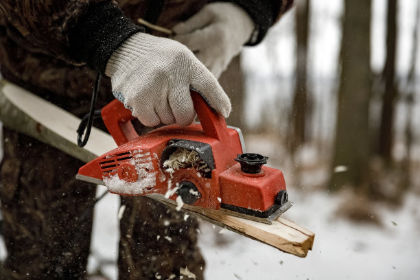电刨特写。一个戴着手套的男人在冬天的大街上和一架红色的电动飞机一起工作图片下载