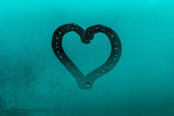 孩子的图画或形象的心在蓝色和绿色的傍晚或早晨的窗户玻璃与滴图片下载