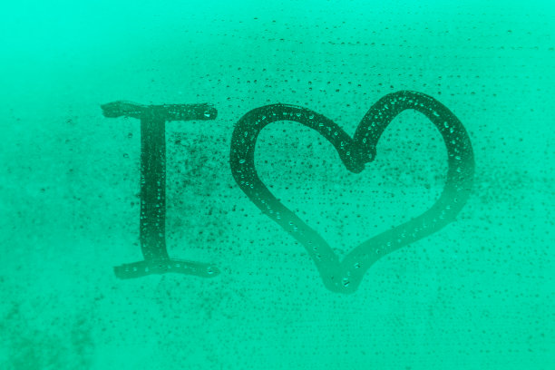 蓝色和绿色的夜晚或早晨的窗户玻璃上滴着浪漫的“我爱你”图片下载