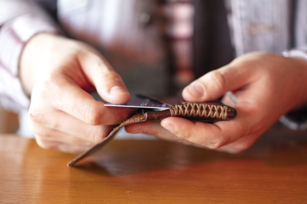 一名男子手里拿着一张信用卡，从钱包里拿出了信用卡图片下载