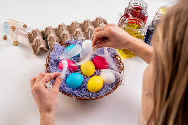 妇女用彩色的鸡蛋装饰复活节篮子图片下载