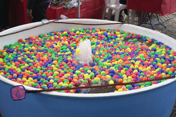 用勺子舀塑料蛋球。图片下载