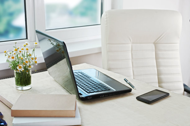 工作地点:笔记本电脑在桌子和扶手椅上图片下载