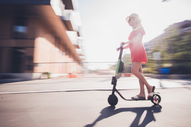 骑电动车的年轻女子。图片下载