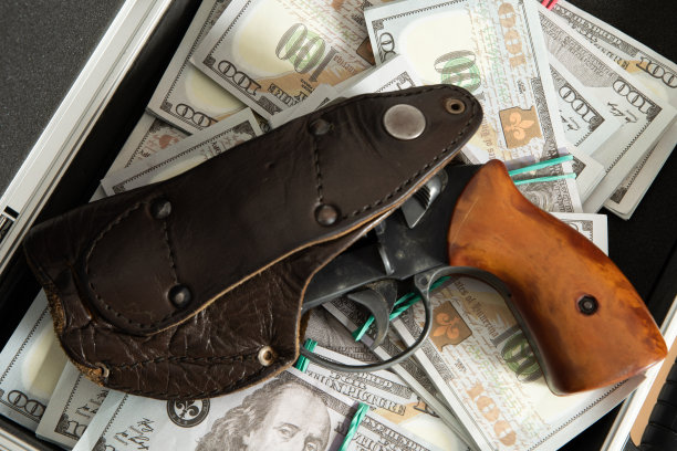 一支枪和一大笔钱卷在一个管子里，背景是黑色的图片下载
