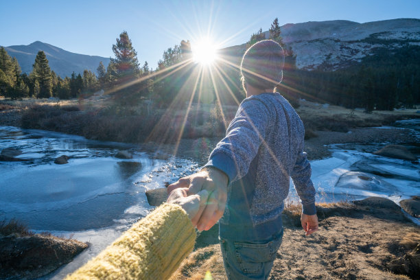 跟随我的概念，年轻的男子带领女友到冻结的河流日落，美国图片下载