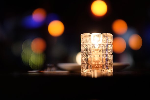 靠近桌上的玻璃蜡烛灯。图片下载