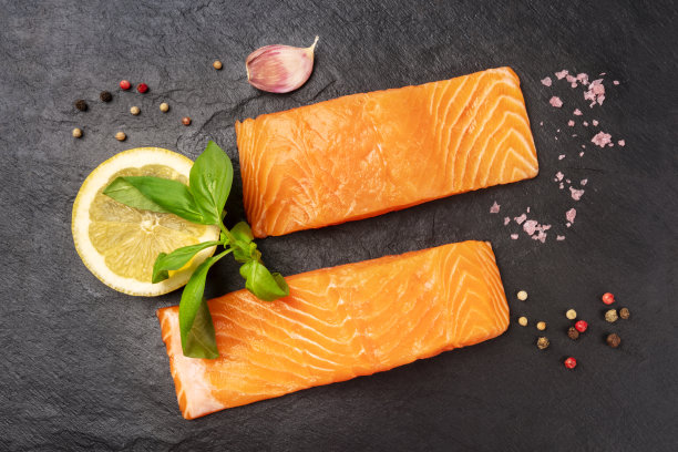 两片生鲑鱼，加入罗勒，盐，胡椒，大蒜和柠檬图片下载