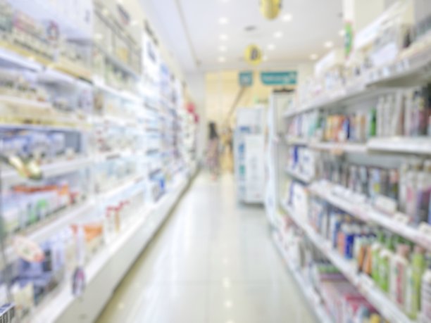 药店或药店模糊的背景与药品货架和模糊的药品，化妆品和药品供应的货架内零售商店内部图片下载
