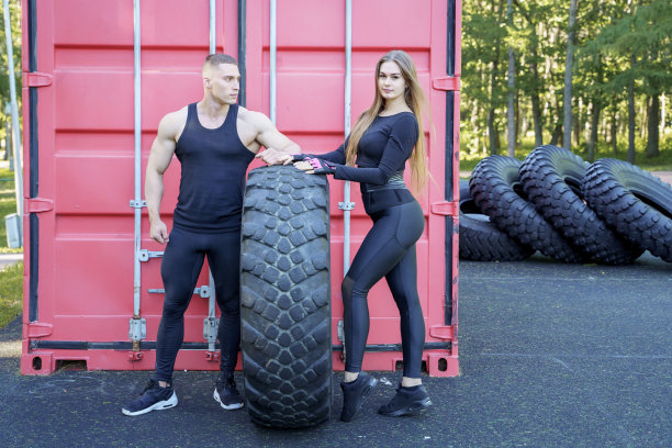 有吸引力的运动夫妇摆姿势后轮胎附近的锻炼图片下载