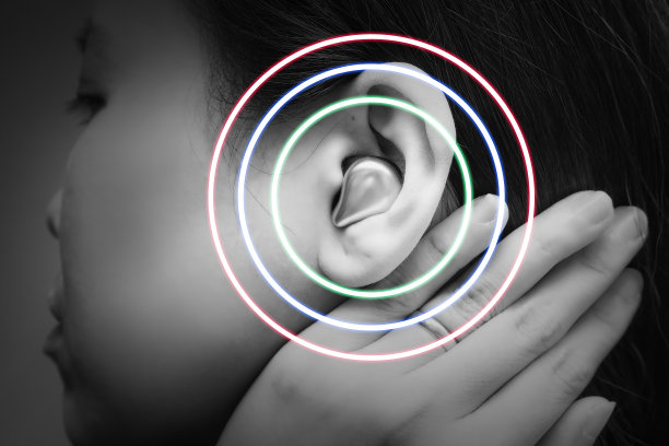 真正的无线蓝牙耳机在亚洲年轻女子的耳朵里，用圈波环绕耳朵，用于舒适的交流或听音乐。黑白色调图片下载