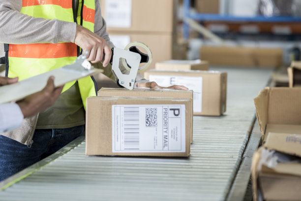 无法识别的配送仓库员工使用磁带分发器图片下载