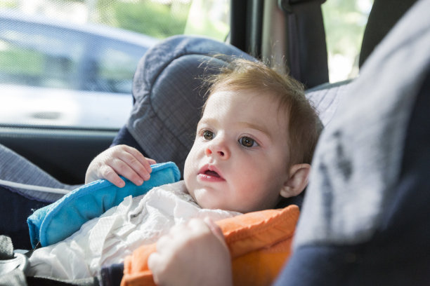 可爱的金发碧眼的小女孩，在车座上系着安全带开心的要走在路上。春夏季节图片下载