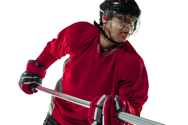 手持球杆在冰场上的男曲棍球运动员，白色背景图片下载