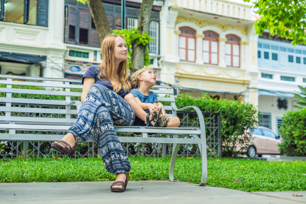 母子在马来西亚槟城乔治市老城区的旧房子背景前图片下载