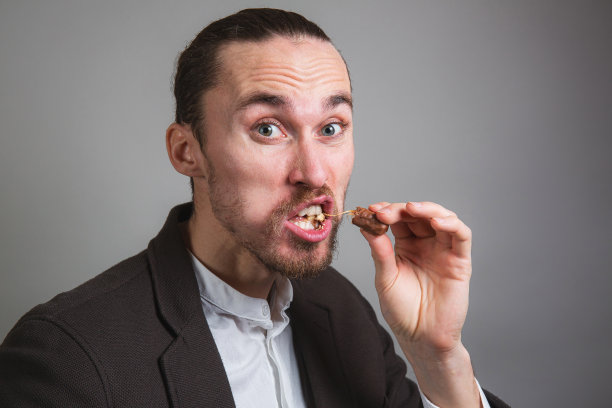 有趣的商务男人在工作时吃零食图片下载