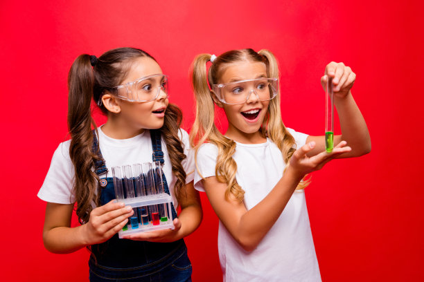 两个有趣的小女士勤奋的学校孩子的照片化学实验令人兴奋的结果持有管穿安全规格整体t恤孤立的红色背景图片下载