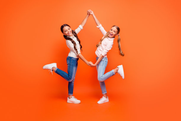 完整的照片积极疯狂的两个孩子小女孩放松的乐趣在伟大的秋天假期手牵手穿休闲装白色运动鞋孤立在明亮的颜色背景图片下载