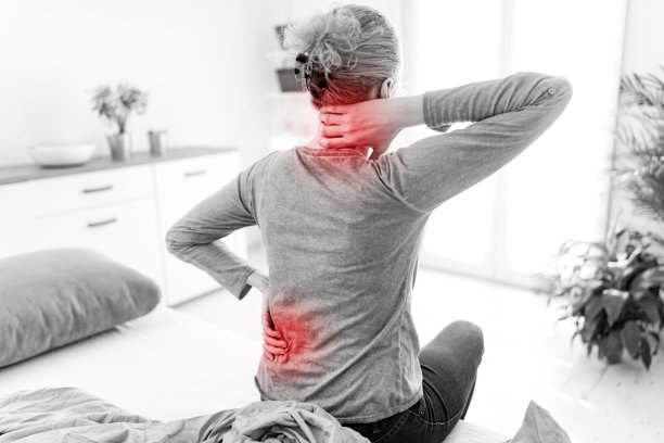 女人在床上醒来，早上伸懒腰，后背和脖子都疼。图片下载