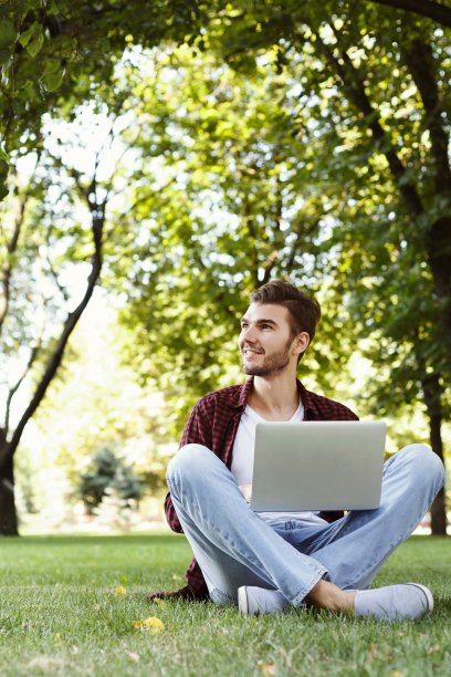 英俊的年轻人在户外使用笔记本电脑图片下载