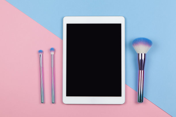 visagiste的现代工作空间，俯视图。平板，化妆笔刷双色背景粉蓝，复制空间，平铺。小型企业，在家工作，使用技术概念。水平图片下载