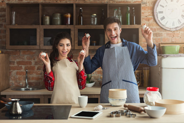 快乐的年轻夫妇在阁楼厨房烘焙图片下载