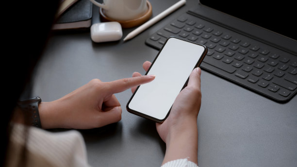 女子在黑色桌面上触摸智能手机空白屏幕的局部照片图片下载