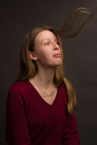 工作室里画着金色头发，穿着红色毛衣的女孩肖像图片下载