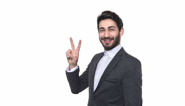 微笑的年轻人在白色背景下做和平手势的肖像图片下载