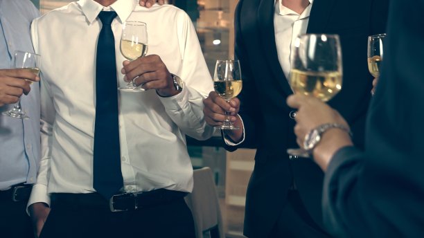 成功的商业人士在舞厅晚宴上喝葡萄酒和香槟。图片下载