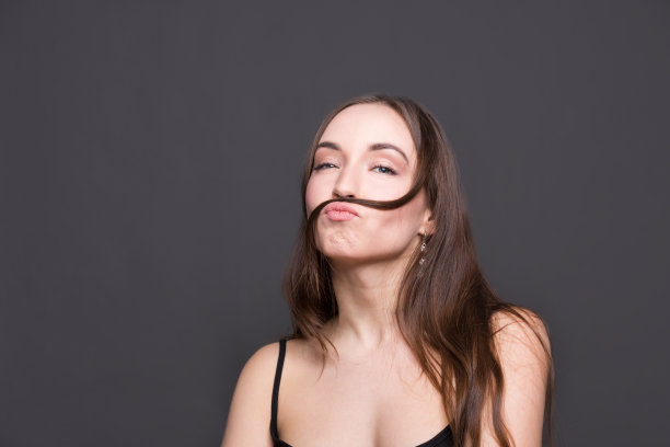 美丽的现代女孩玩她的头发图片下载