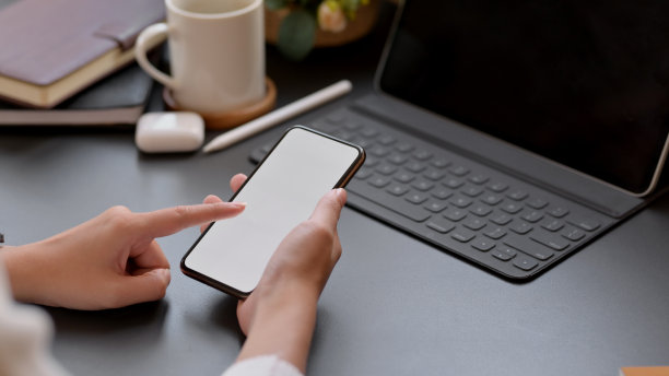 女子在黑色桌面上触摸智能手机空白屏幕的局部照片图片下载