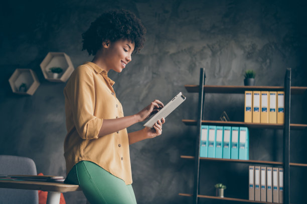 简介侧面的照片聪明凉爽的非洲裔美国房地产经纪人工作平板电脑读创业新闻聊天与公司同事在阁楼办公室图片下载