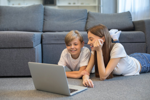 快乐漂亮的年轻女人和她的小儿子在客厅里图片下载