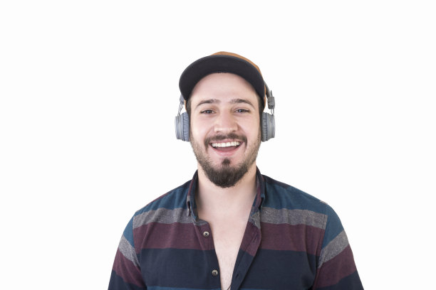 白色背景下戴着耳机微笑的年轻人的肖像图片下载