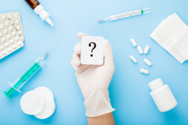 医生戴橡胶防护手套展示问号，浅蓝色桌面背景，疫情期间的不同治疗药物，医疗问题概念，俯视图片下载