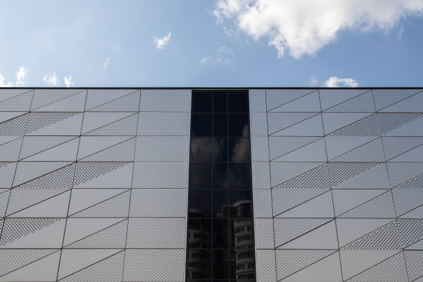 建筑的地面视图，三角形的图案和圆形的开口在墙上和黑色的玻璃在墙的中间图片下载