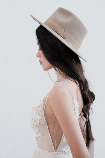 新娘的肖像。一个年轻迷人的黑发女子，梳着长长的黑发。白色婚纱和米色帽子。乡村风格，一束麦穗。图片下载