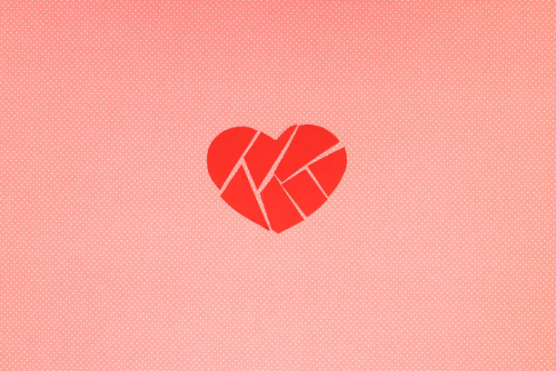 粉色背景上的破碎红心图片下载