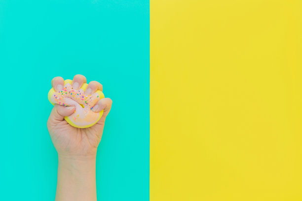 手持粉色甜甜圈玩具，缓解压力图片下载