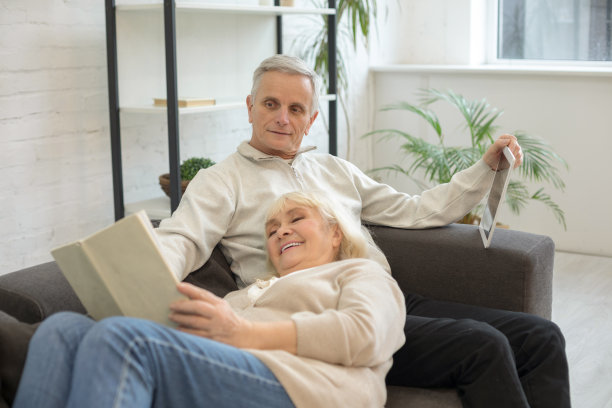 在家中沙发上休息的微笑中年夫妇图片下载