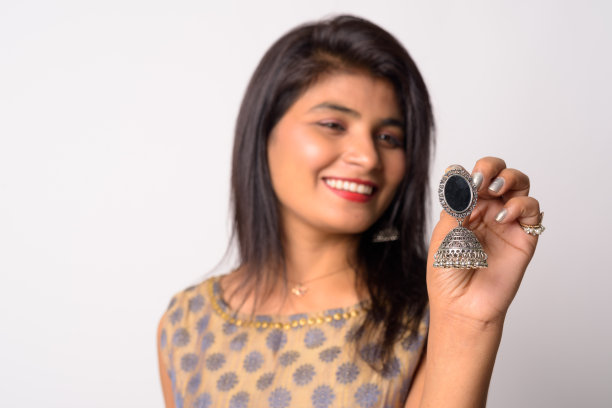 快乐的年轻波斯女子穿着传统服装，手持耳环图片下载