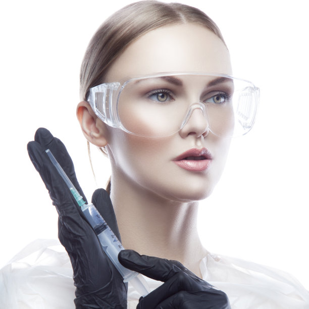 美丽的女医生拿着注射器，穿着医疗制服，戴着黑色橡胶手套图片下载