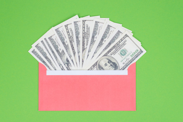 从银行概念中获取信用存款资金。最上面的近景照片，装满钱的红包孤立在明亮的绿色背景图片下载