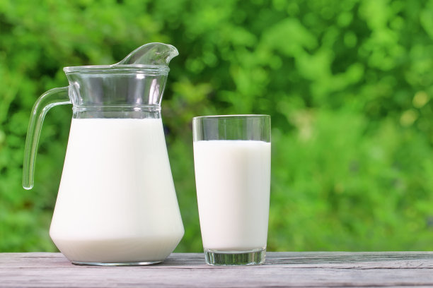 木桌上放着水壶和一杯牛奶图片下载