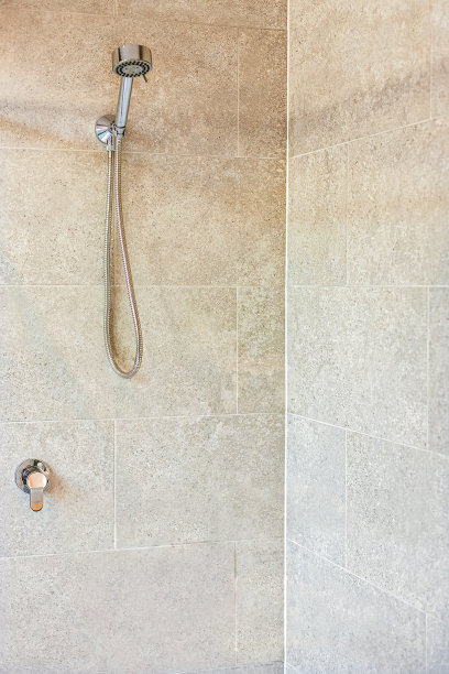 现代浴室淋浴区，墙上有银色水龙头图片下载