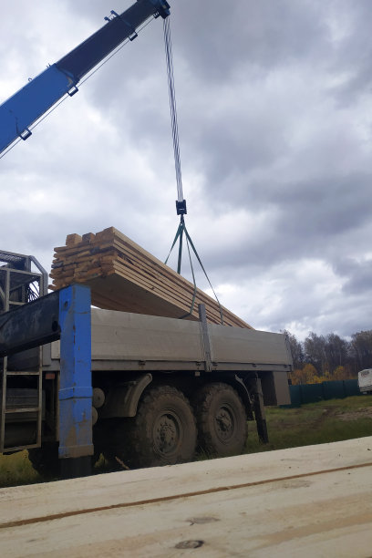 起重机将货物板运送到施工现场，工人移除带子图片下载