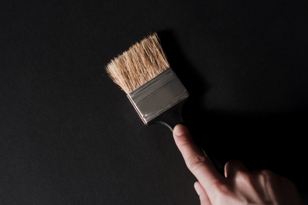 黑色画笔在女人的手中在黑色的背景图片下载