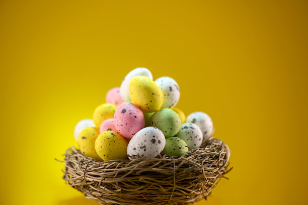 复活节彩蛋在一个巢黄色背景与复制空间图片下载