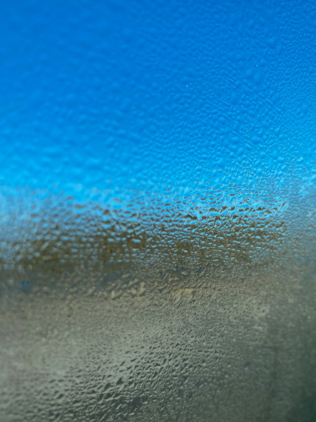 蓝色玻璃背景上的天然水滴。春夏雨点落在车窗上。移动垂直照片图片下载